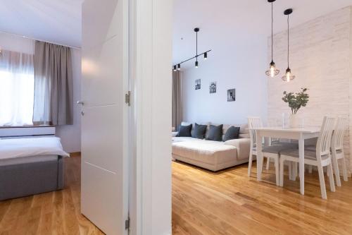 a living room and dining room with a couch and a table at President Apartman 7 in Vračar (historical)