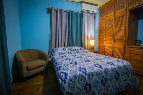 a bedroom with a bed and a chair and a window at Traum House in Saint Augustine