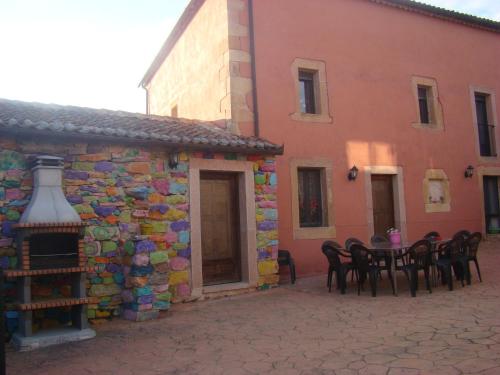 a patio with a table and chairs next to a building at La Perseverancia in Aldehuela