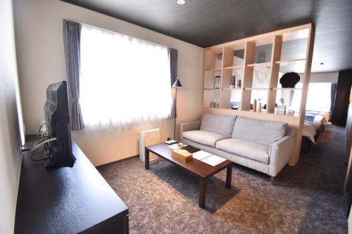 a living room with a couch and a table at K-style 御所西 in Kyoto