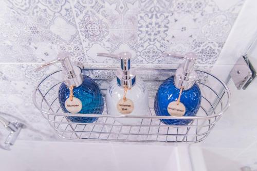 three blue glass toothbrushes in a basket in a bathroom at Ruanmata Homestay in Chiang Mai
