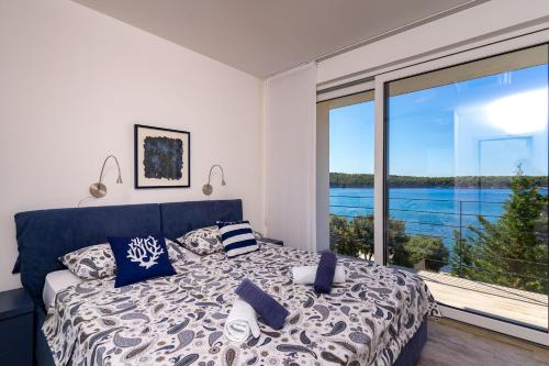 a bedroom with a bed and a large window at OlivaBeachHouse - Direct Waterfront & Mooring in Barbat na Rabu