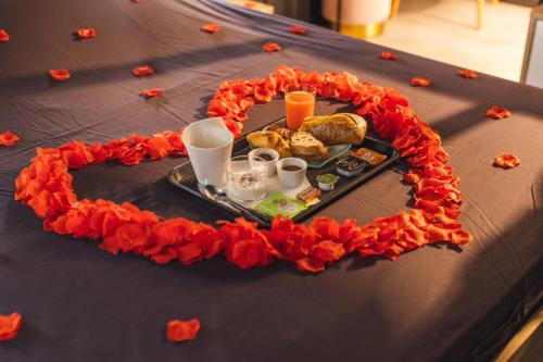 einen Tisch mit einem Tablett mit Essen und Orangenblüten in der Unterkunft Eden House, Cocon intimiste et romantique avec jacuzzi in Carpentras