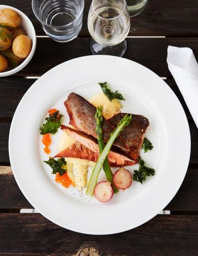 a plate of food with meat and vegetables on a table at Rimforsa Strand in Rimforsa
