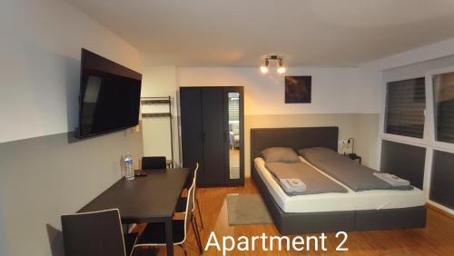 1 dormitorio con cama, mesa y escritorio en SEVIS Outlet Apartments en Metzingen