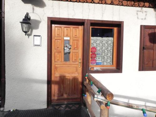 - une porte en bois sur un bâtiment avec une fenêtre dans l'établissement Le Vieux Rascard Chambres d'Hotes, à Champoluc