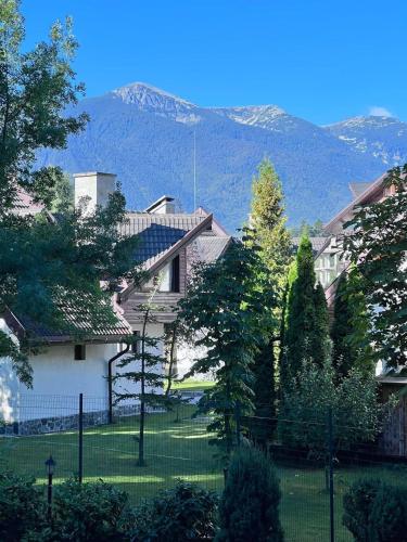 a house with a yard with mountains in the background at Cosy studios with mountain view near Bansko in Razlog