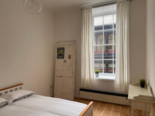 1 dormitorio con cama y ventana en Lovely 1-Bed Apartment in Glasgow Merchant City en Glasgow