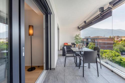 a dining room with a table and chairs and a large window at Sasso Boretto, Luxury Holiday Apartments in Ascona