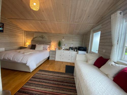 1 dormitorio con 2 camas y sofá en Adorable Cabin in the Countryside, en Portlaoise
