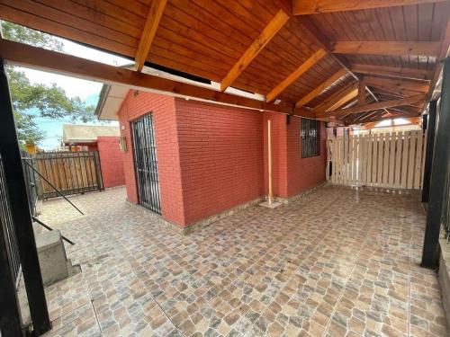 eine Terrasse mit Ziegelwand und Holzdecke in der Unterkunft Casa la serena condominio D. Gabriela in La Serena