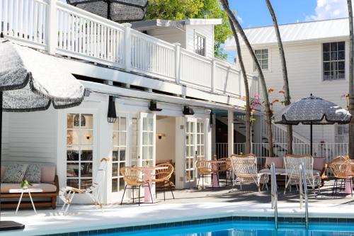 a patio with a pool and chairs and a house at Lighthouse Hotel - Key West Historic Inns in Key West