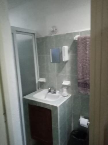 een badkamer met een wastafel en een spiegel bij Apartamento Vacacional con A/C in Cozumel