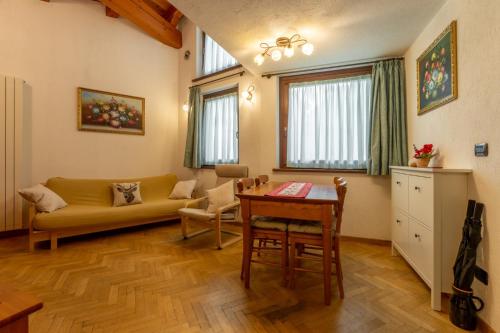 a living room with a couch and a table at La Maison de Elisa - A pochi passi dallo SCI in Courmayeur