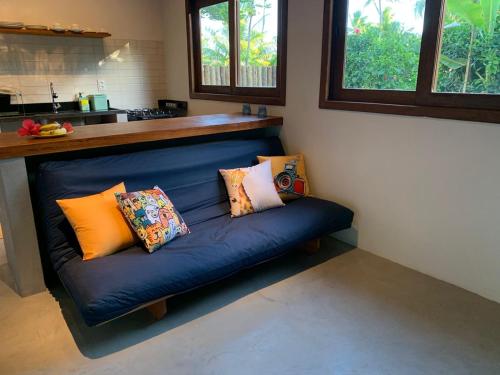 um sofá azul com almofadas na cozinha em Casa Hibiscus na Ilha de Boipeba