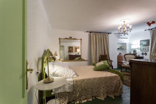 een slaapkamer met een bed met een tafel en een spiegel bij Le Giuggiole 5 posti letto in una casa ricca d'atmosfera in Farra dʼlsonzo