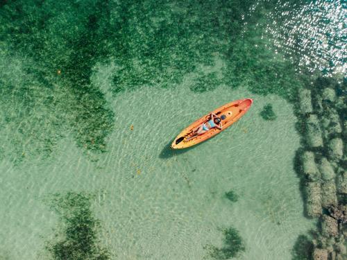 un kayak naranja en el agua en el océano en Rosario EcoHotel en Isla Grande