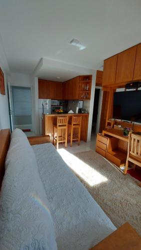 uma sala de estar com uma cama grande e uma cozinha em Cosy Apartment in Fantastic Location in City Center em Poços de Caldas