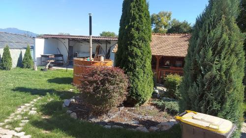 a garden with trees and a house in the background at Casa Nicholas in Zărneşti