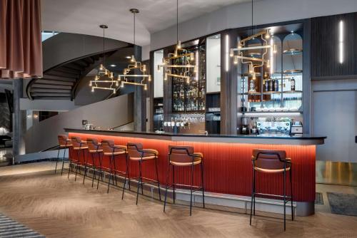 a bar in a restaurant with stools at Radisson Blu Latvija Conference & Spa Hotel, Riga in Rīga