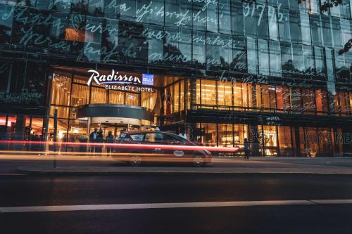 a taxi cab parked in front of a building at night at Radisson Blu Elizabete Hotel, Riga in Rīga