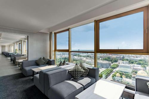 a waiting room with couches and tables and large windows at Radisson Blu Latvija Conference & Spa Hotel, Riga in Rīga