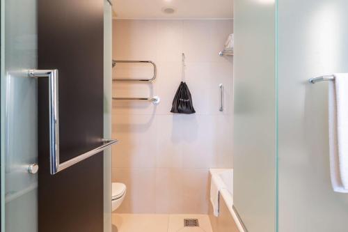 a bathroom with a toilet and a glass shower door at Radisson Blu Elizabete Hotel, Riga in Rīga