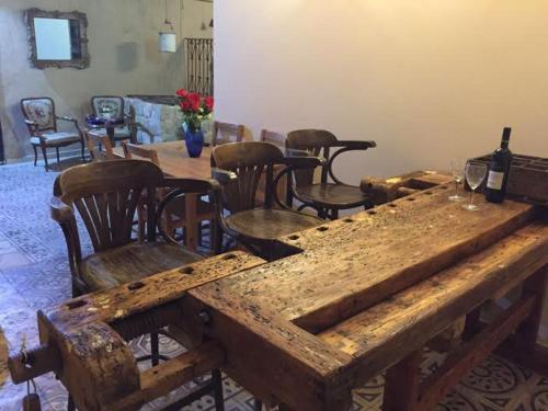 a large wooden table with chairs and wine glasses at Boutique Agam Hahoresh - בוטיק אגם החורש in Haifa