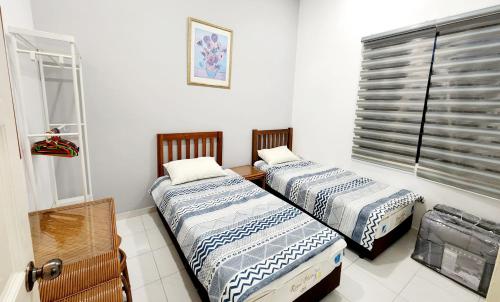 two beds in a room with a window at BK House Melaka in Melaka