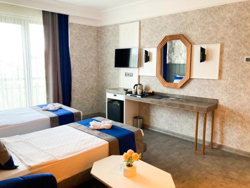 een hotelkamer met 2 bedden en een spiegel bij NENESSAHOTEL in Aksaray