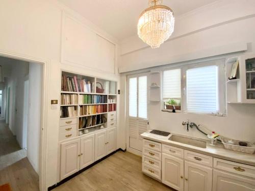 a kitchen with white cabinets and a chandelier at 150m² Live/Work Unique&Sunlit Space in Athens in Athens