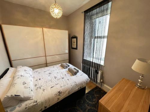 um quarto com uma cama, uma janela e um candeeiro em The Beach Front Apartment, Amazing Frontline Sea Views em Tynemouth