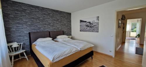 Ferienwohnung Schwarzwaldblick في Vörstetten: سرير في غرفة نوم مع جدار من الطوب