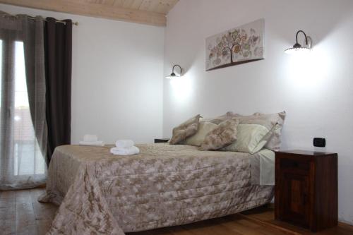 1 dormitorio con 1 cama en una habitación con ventana en GUEST HOUSE TZIA UDRONI, en Ossi