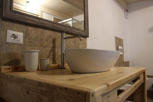 un cuenco blanco en un mostrador de madera con espejo en GUEST HOUSE TZIA UDRONI, en Ossi