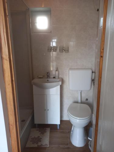 een badkamer met een toilet, een wastafel en een bad bij GALAMBLAK Vendégház in Abaújszántó