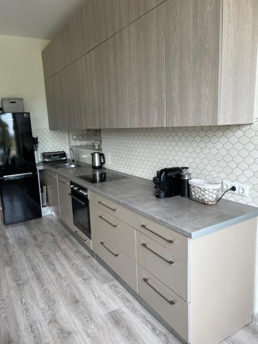 a kitchen with white cabinets and a counter top at Zeltāres in Jelgava