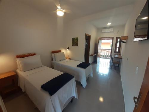 a hotel room with two beds and a balcony at Caminho da areia in Ubatuba