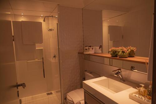 a bathroom with a shower and a sink and a toilet at Blue Flat Pedra Azul - Com Vista pra Pedra in Pedra Azul