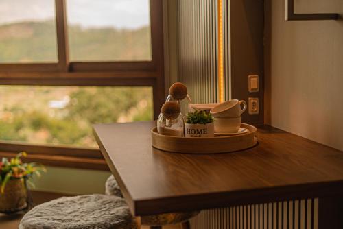 a table with two figurines on top of it with a window at Blue Flat Pedra Azul - Com Vista pra Pedra in Pedra Azul