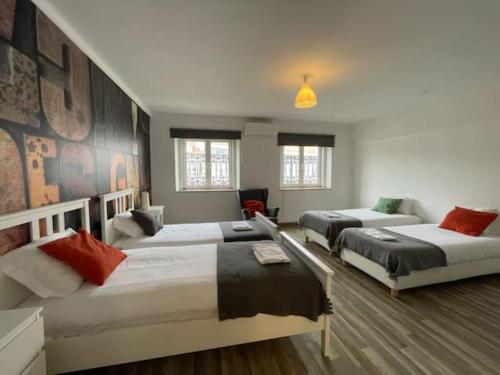 a bedroom with three beds and a couch at Santos Deluxe Apartment in Lisbon