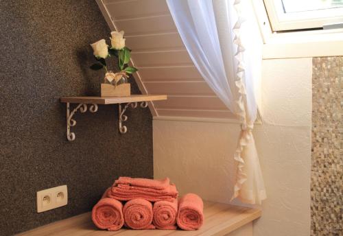 a pile of towels sitting on a shelf next to a window at B&B Adem in Horebeke