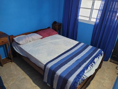 Dormitorio azul con cama con manta a rayas en EL RINCON DE ROSA 2 en 