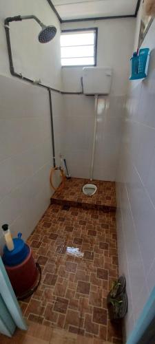 a small bathroom with a brick floor and a window at Hometostay Bokbak Kupang 