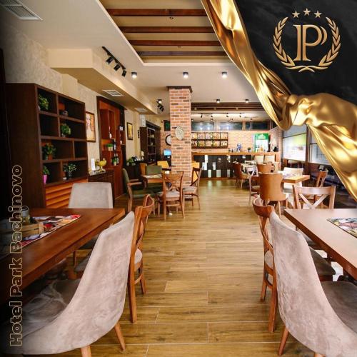 a restaurant with wooden tables and chairs and a dining room at Hotel Park Bachinovo in Blagoevgrad
