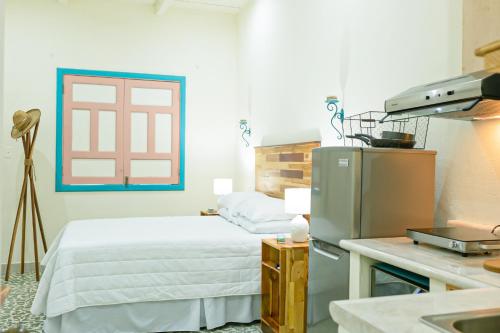 a small bedroom with a bed and a refrigerator at Elegant House The Heart Of Flores in Flores