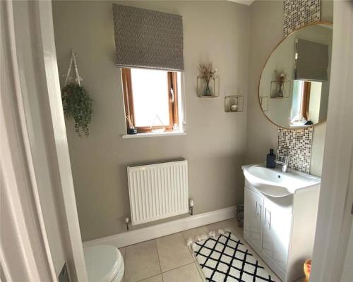 bagno con lavandino, servizi igienici e specchio di Tide Cleddau impressive detached 4 bedroom home - Llanreath a Llanstadwell