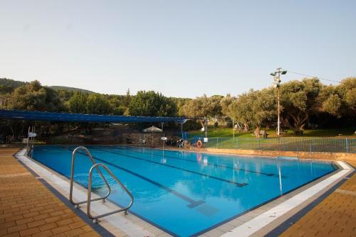 a large swimming pool with blue water at Mantur Parod by Selina in Parod