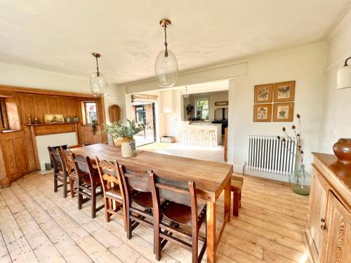 a kitchen and dining room with a wooden table and chairs at Highview House Norfolk Coast - seaviews, beach, hot tub in Mundesley