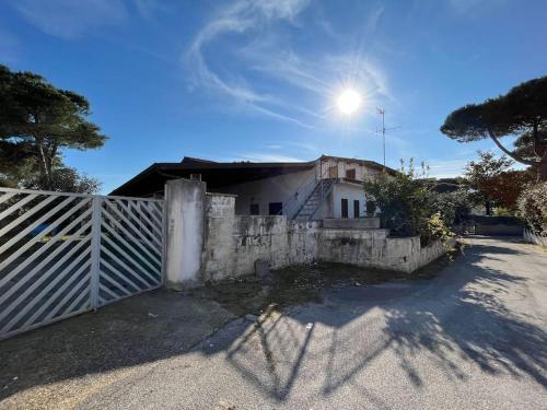 una casa con una valla delante de ella en Villa Multifamiliare a 300mt dal Mare, en Baia Domizia